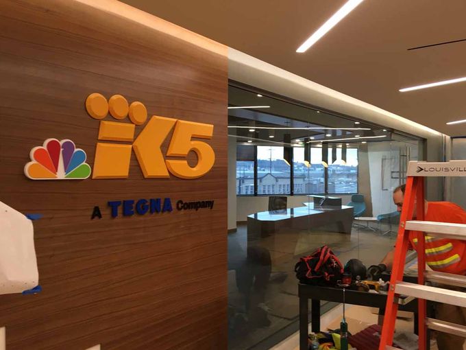 Interior signage with the required "A Tegna company" tagline