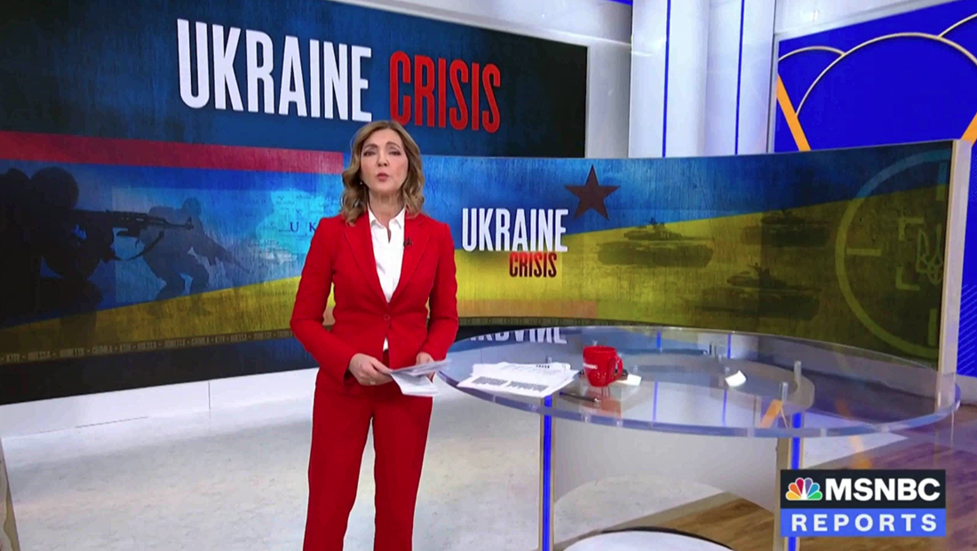 A news anchor standing in front of a 'Ukraine Crisis' graphic